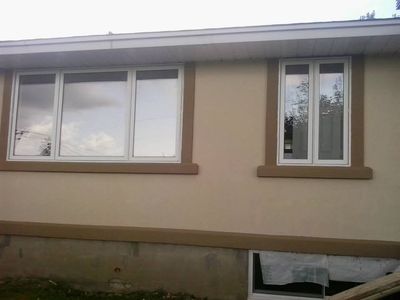 Fachada terminada: acabado acrílico crema, marcos y zócalo marrones.
