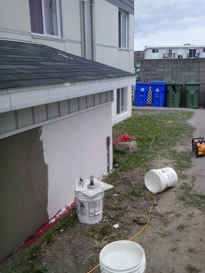 Aplicación de revestimiento acrílico blanco sobre un cimiento reparado.
