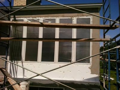 Capa base aplicada alrededor de las ventanas, todavía secándose.