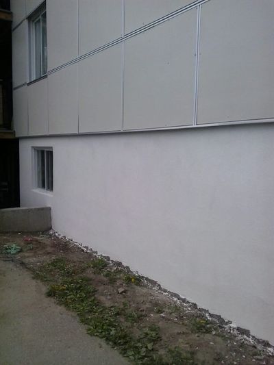 Detalle del acabado acrílico blanco sobre un cimiento recién revestido.