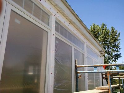 Preparación del muro: malla fijada al sustrato y ventanas protegidas con plástico.